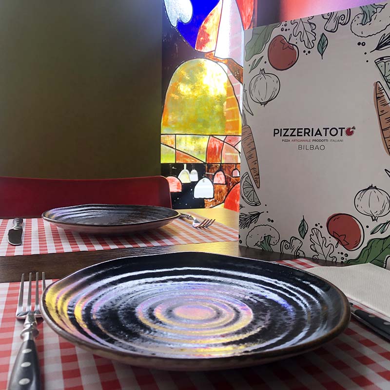 mesa puesta con plato y carta de Pizzeria Totó Bilbao